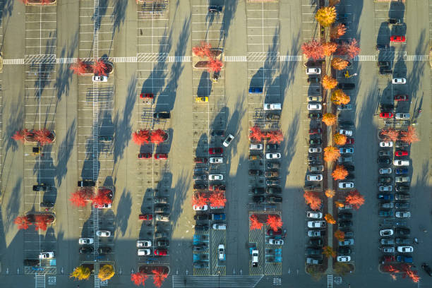 view from above of many parked cars on parking lot with lines and markings for parking places and directions. place for vehicles in front of a strip mall center - strip mall shopping mall road street zdjęcia i obrazy z banku zdjęć