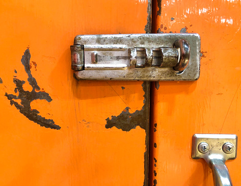 Silver Lock on Bright Orange Distressed Doors