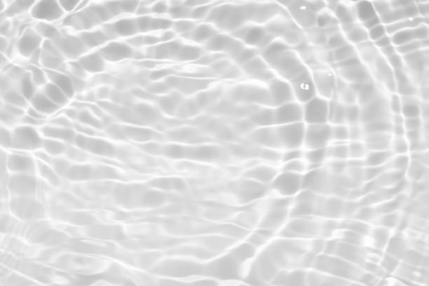 istock White water with ripples on the surface. Defocus blurred transparent white colored clear calm water surface texture with splashes and bubbles. Water waves with shining pattern texture background. 1953664924