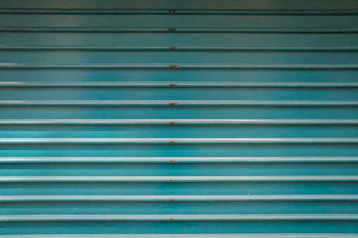 A modern teal horizontally-corrugated metal surface.