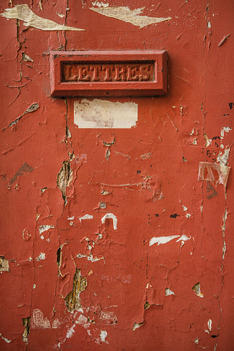 An old red mail slot that says 