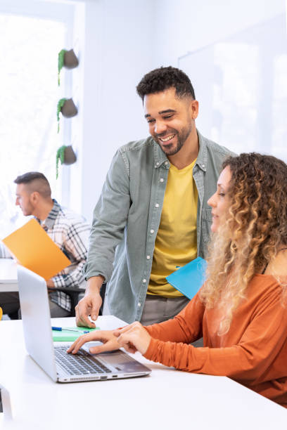 istock Coworkers engaging over laptop in sunny office 1953704572