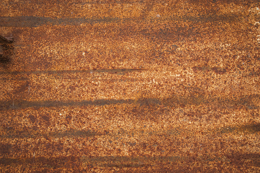 An old streaked rusty orange metal surface.
