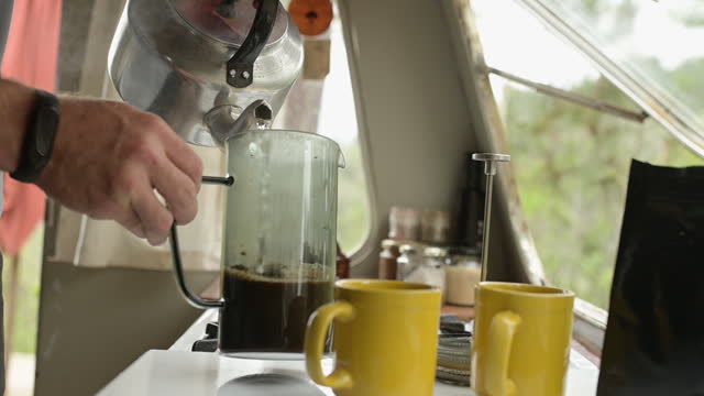 Boiling, water and kettle on stove for coffee, tea and hot beverage in kitchen in morning. Home, electrical boiler and hands of person with appliance with heat, steam or liquid in cup for preparation
