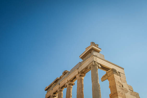 A corner of the Parthenon in Greece, against blue sky.