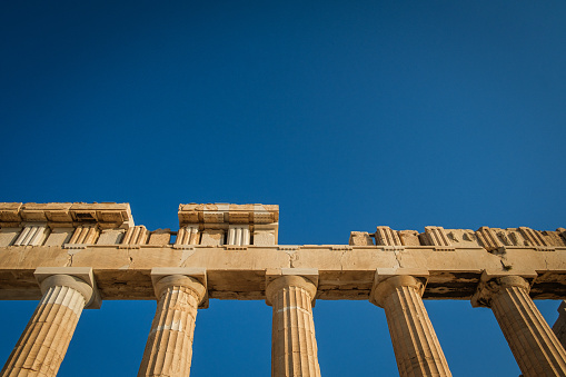 The edge of the Parthenon in Greece, against blue sky.