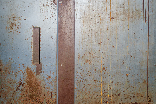 A streaky, rusty steel door.