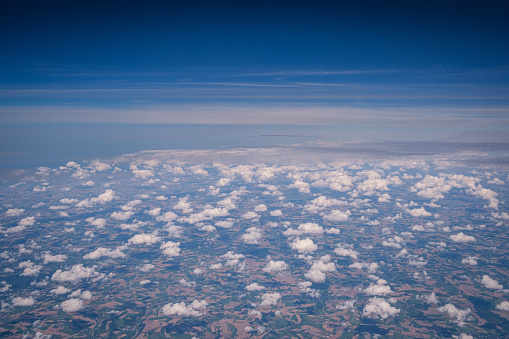 A high angle view of sky and clouds over land from an airplane.