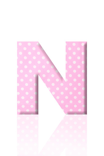 Close-up of three-dimensional polka dot alphabet letter N on white background.