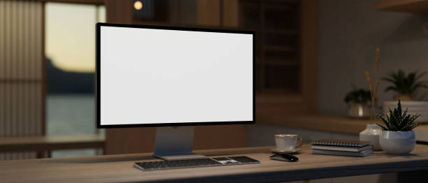 istock A modern private office with a PC computer and accessories on a table in a dark room in the evening. 1953784881