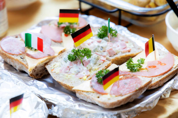 Delicious gourmet sandwich featuring ham, bologna, sausage with fresh vegetables, and cheese on grilled bread.