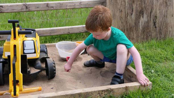 istock Red headed Child playing with toys in Sand Pit 1953856667