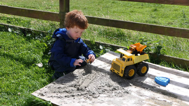 istock Red headed Child playing with toys in Sand Pit 1953856823