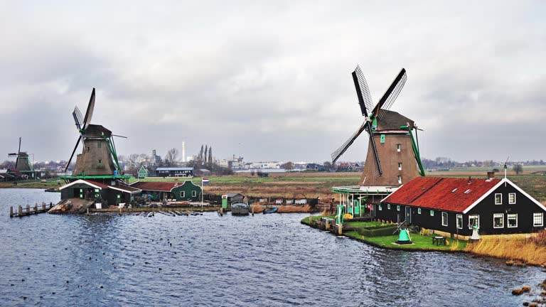 Traditional windmills in Zaanse Schans in the Netherlands, Spinning mills, Rural landscape with windmills in the Netherlands, Ancient wooden windmills in Zaanse Schans, the most popular tourist attraction in the Netherlands