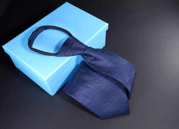 istock A zipper necktie laid over gift box on dark background close up view 1953902344