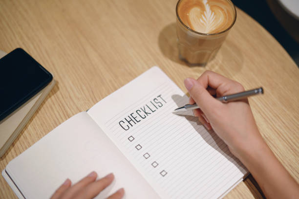 istock Close up woman's hand holding a pen and writing down  checklist in a notebook 1953902849