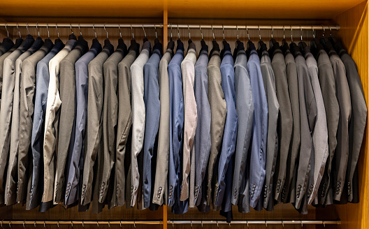 Business jackets hanging on a clothing rack at a store - fashion concepts