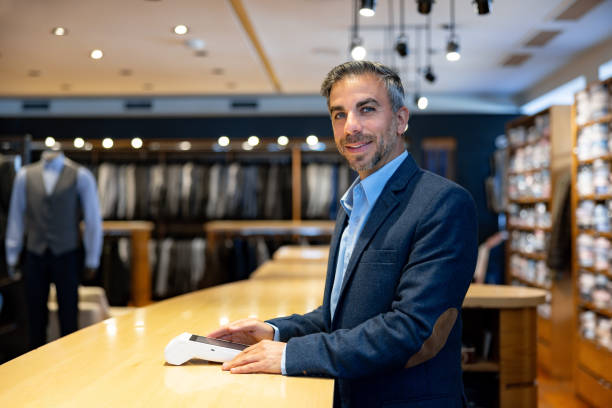 Happy salesman working at a clothing store