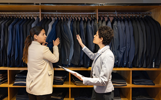 Business manager training a new employee at a clothing store - small business concepts