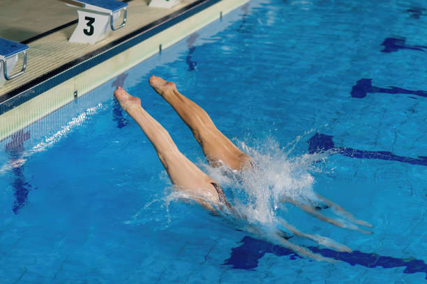 istock Synchronized grace, the duo jumping into the pool 1954143088