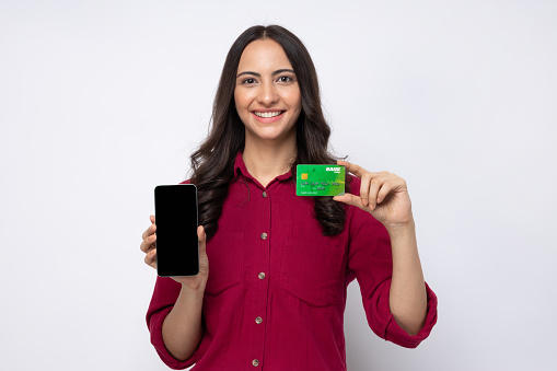 Photo of cheerful girl hold credit card new model smart phone showing isolated white background