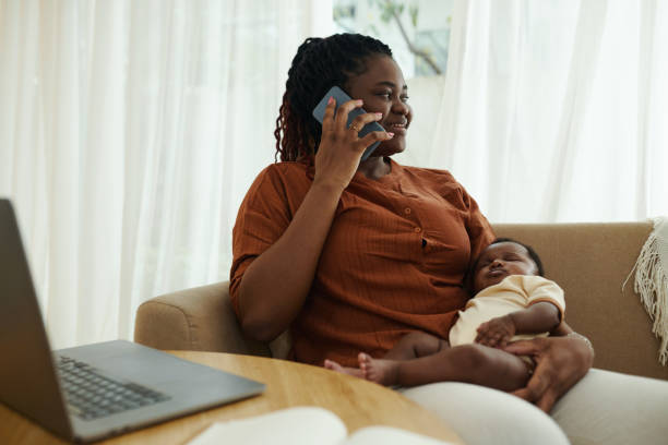 istock Mother with Sleeping Baby Talking on Phone 1954197895