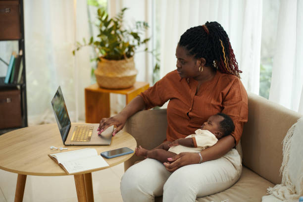 istock Black Woman with Baby Working on Laptop 1954197896