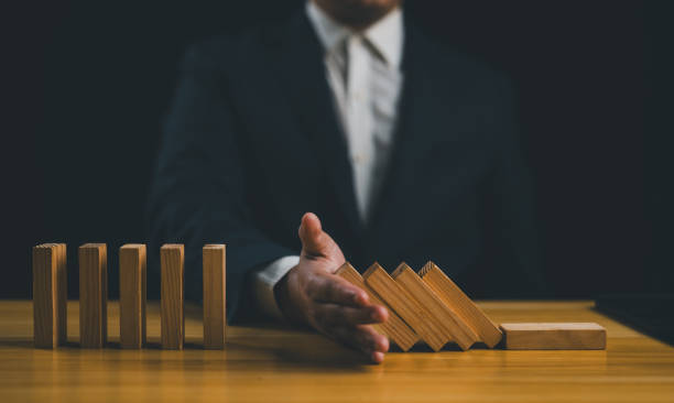 istock Hand stopping the domino business crisis effect or risk protection concept, Business solution and intervention. 1954202132