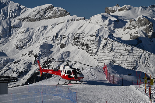 Wengen Switzerland, Switzerland – January 11, 2024: A Swiss helicopter waiting for guests to fly over Maennlichen mountains in Bernese Oberland, Switzerland