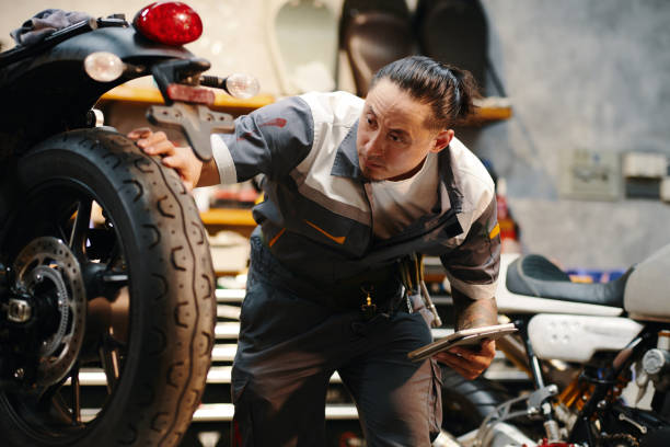 istock Repairman Checking Wheels and Tires 1954221498