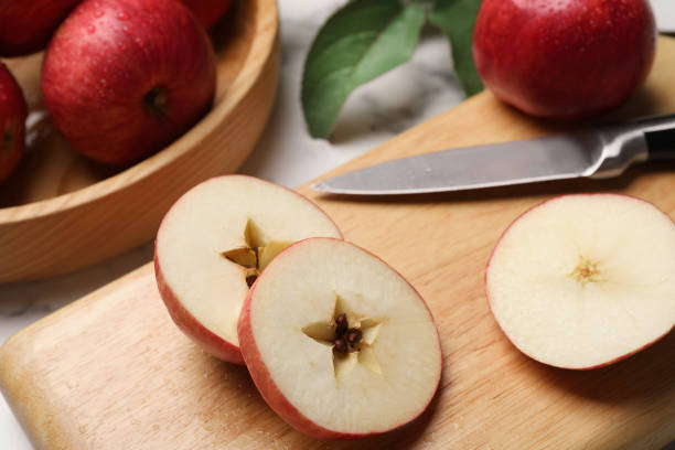 istock Cut red apple and knife on white table, closeup 1954234830
