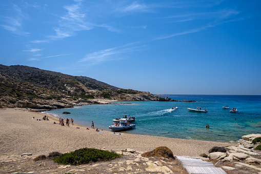 Ios, Greece - September 15, 2023 : View of tourists arriving by speed boats and enjoying one the most amazing turquoise beaches of Greece, Pikri Nero beach on the island of Ios Greece