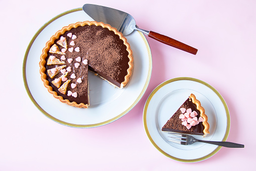 Valentine sweets. delicious chocolate tart/ pale pink background.