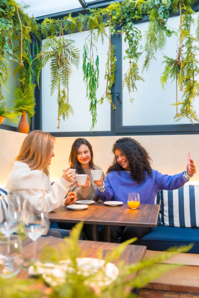 istock Women taking selfie sitting together in a cafeteria 1954252443