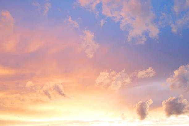 Abstract Background. Sunrise Sky. Yellow- Orange- Purple - Blue Color Gradient. Horizontal Pattern Of Spots Of Illuminated Clouds.