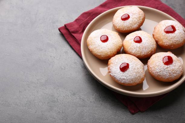 istock Hanukkah donuts with jelly and powdered sugar on grey table, space for text 1954253344