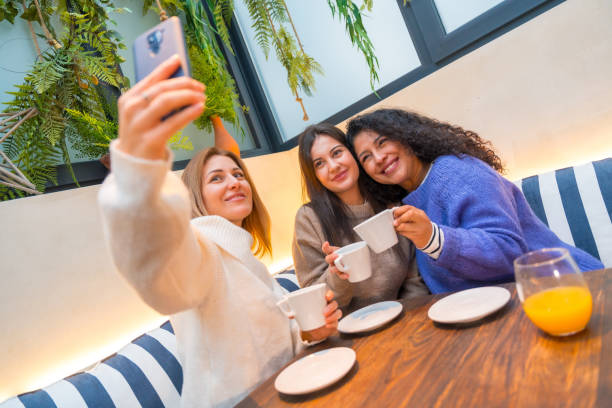 istock Women taking a selfie while drinking coffee in a cafeteria 1954261392