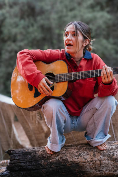 istock Blonde girl singing and playing the guitar 1954261932