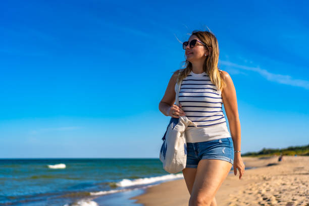 istock Beautiful woman walking on beach 1954264207