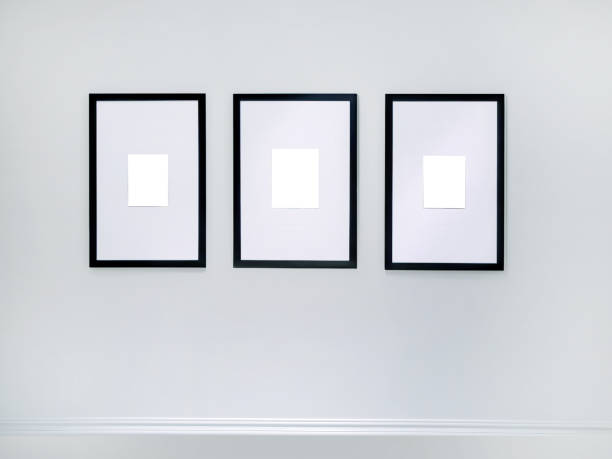 istock Three empty vertical picture frames hanging on white wall, Wall art mockup set of 3 posters, blank space frame modern interior style, minimalist with clipping path 1954264236
