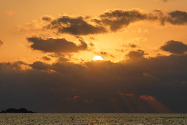Sunset, beach landscape - clouds touching the sea