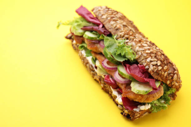 istock Delicious sandwich with schnitzel on yellow background, closeup. Space for text 1954290457