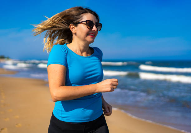 Beautiful woman running on sunny beach