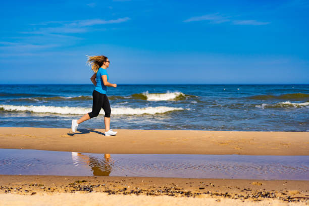 Beautiful woman running on sunny beach
