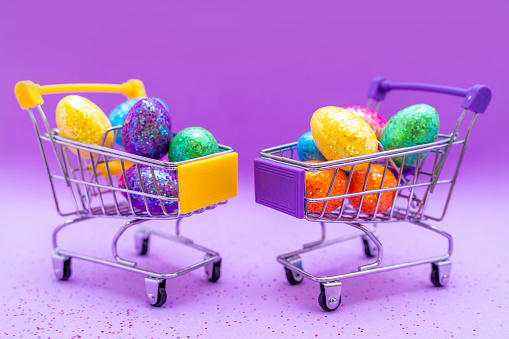 Happy Easter background. Easter eggs are colorful in a shopping basket on purple paper. Holiday concept. Copy space for text