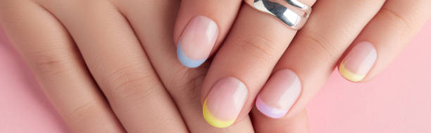 istock Close up manicured womans hands on pink background 1954361063