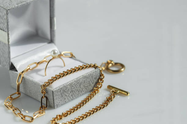 istock Metal chain and jewelry box with ring on white table, closeup. Space for text 1954361881