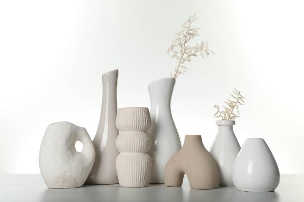 istock Different stylish vases and dried flowers on light table against white background 1954362163