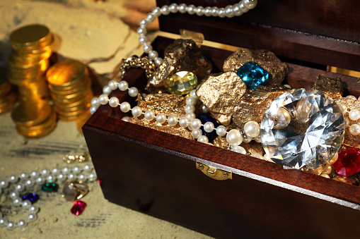 ancient treasures made of gold Packed in a retro treasure chest. Pirate treasure made of wood. Decorated with silver steel. Gold Medal and Golden Jug. white background with clipping path 3d rendering