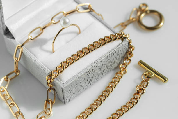 istock Metal chain and jewelry box with ring on white table, closeup 1954362521